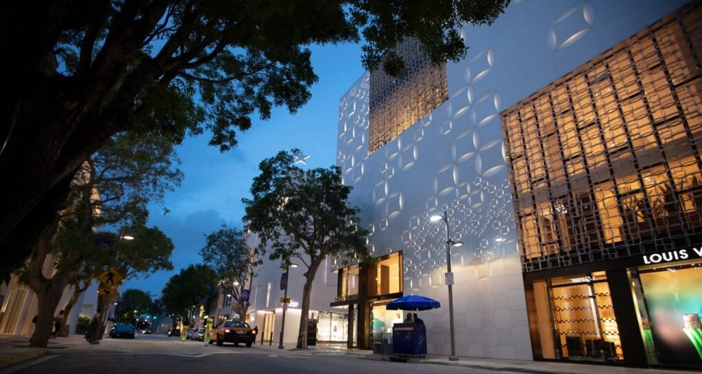 Luxury storefronts at Miami Design District at dusk, featuring Louis Vuitton and upscale architecture, highlighting Miami’s high-end shopping and tourism appeal